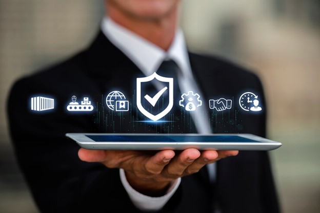 A business professional in a suit holding a tablet with floating cybersecurity icons